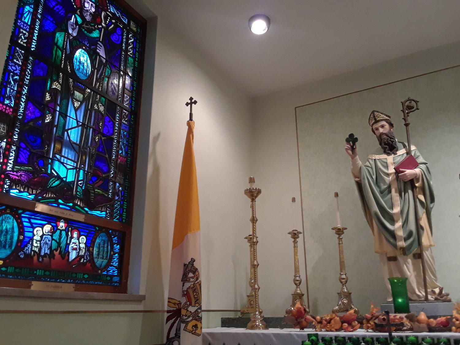 A statue of St. Patrick and a stained glass image patterned after artwork in the Book of Kells, adorn a side chapel in the Shrine of St. Patrick in St. Patrick, Missouri.
